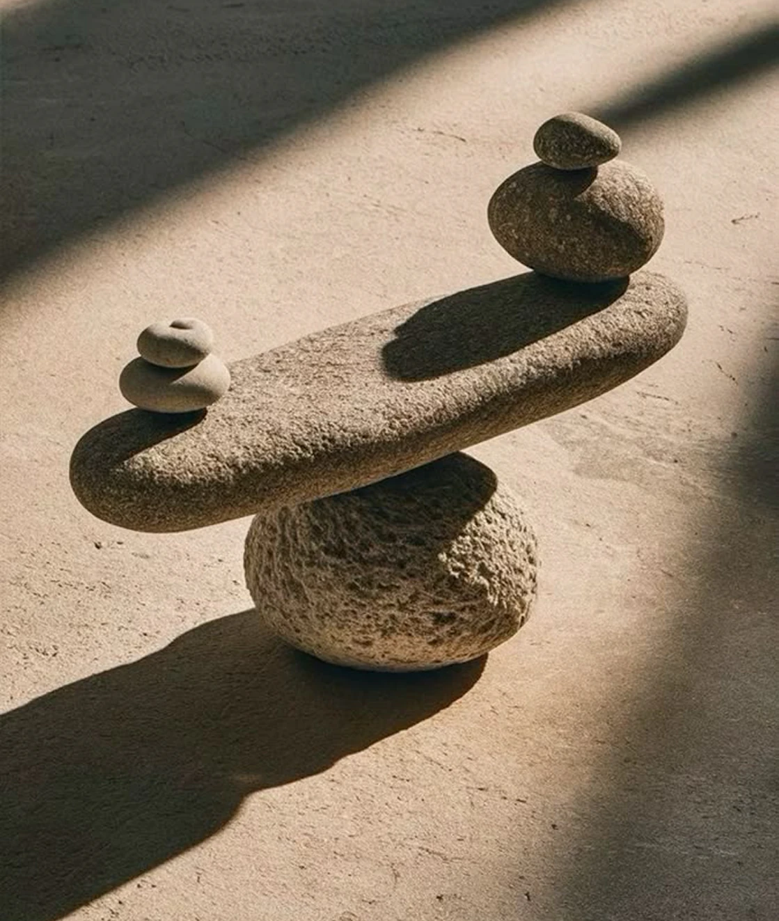 Balanced stones casting shadows on a sunlit surface