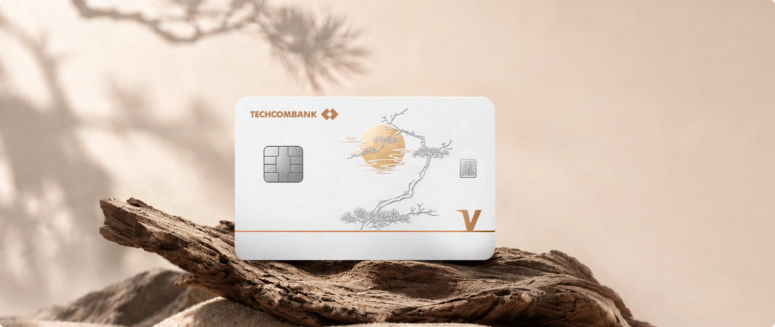 Hai thẻ TechcomWealth Visa Infinite Private trên nền tre và kiến trúc ánh sáng vàng