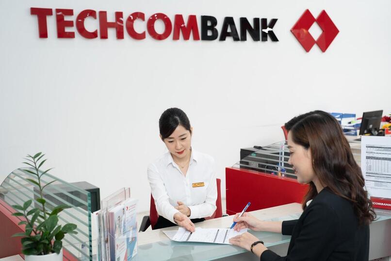 Giao dịch viên Techcombank hướng dẫn khách hàng khóa thẻ và thực hiện thủ tục cấp lại thẻ.